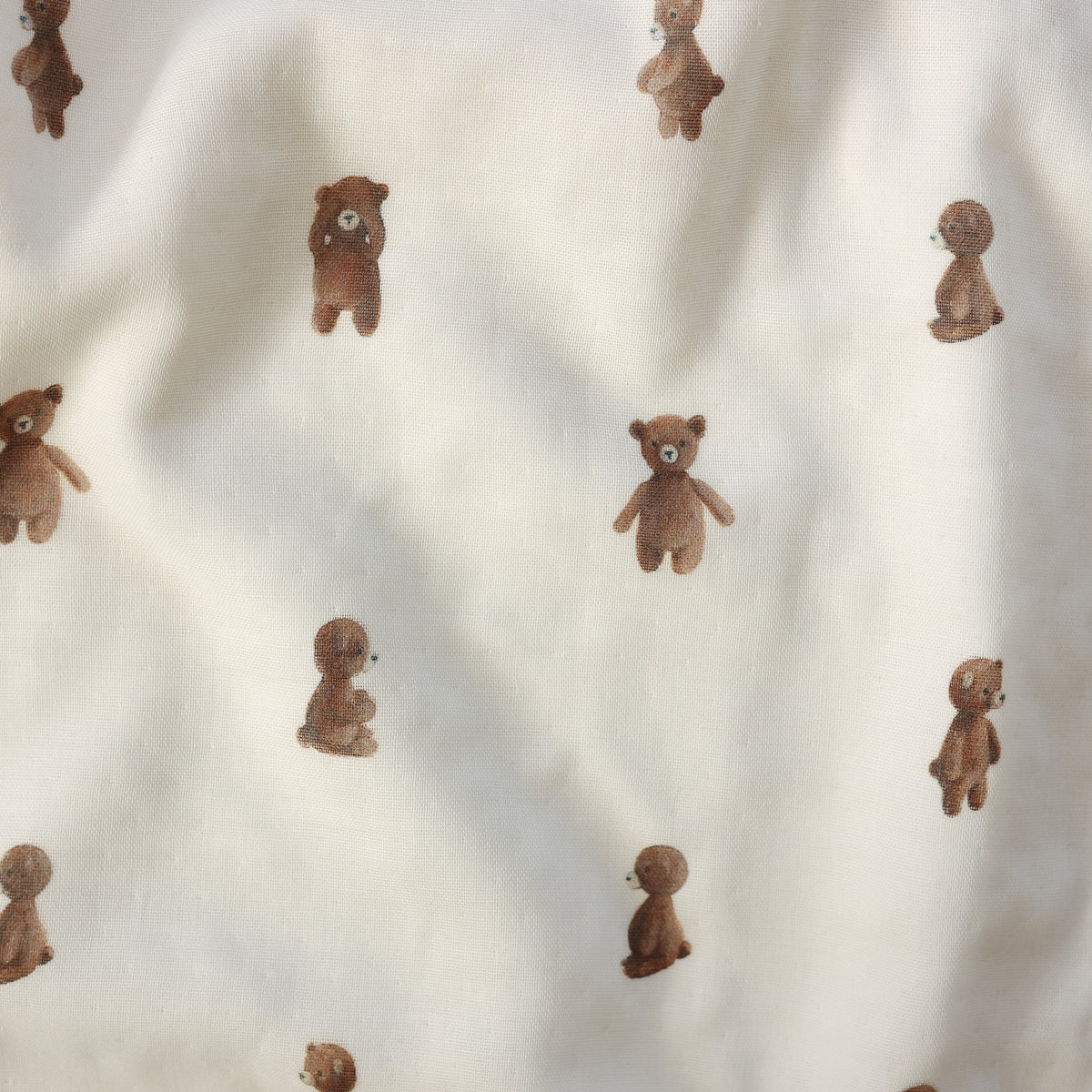 Off-white fabric with a repeating pattern of small brown teddy bears in different sitting poses.