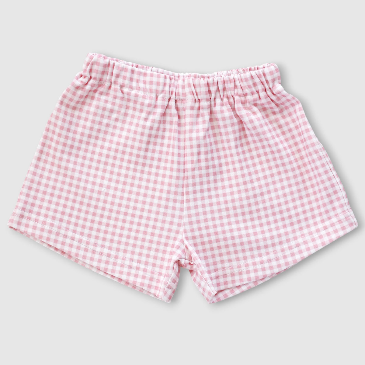 Pink and white gingham checkered baby shorts with an elastic waistband, shown flat on a light gray background.